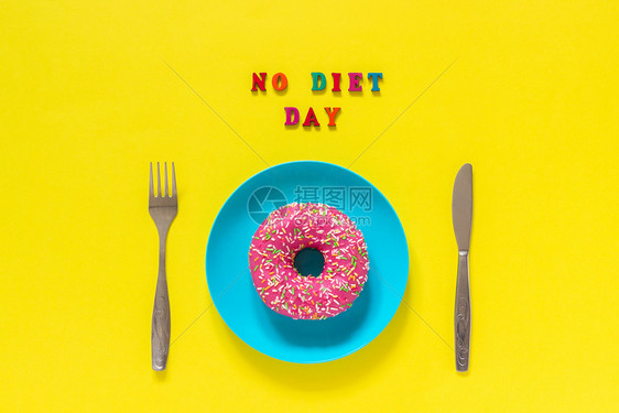 文字NODIETDAY盘子上的粉色甜圈和餐具刀叉5月6日国际无节食概念盘子上的粉红色甜圈和餐具刀叉概念国际无节食日小吃躺着饮图片