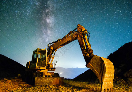 重的夜间作业中挖掘机以夜晚星空为背景夜间作业中的挖掘机以夜晚星空为背景力量采石场图片