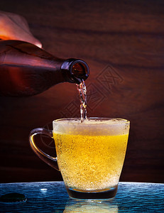 在成人酒吧和餐馆饮时将啤从瓶头排到桌上的玻璃边有木本底用于酒精饮料清爽人们咖啡图片
