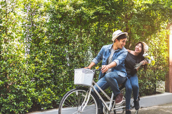 快乐的一对夫妇在浪漫观下一起骑自行车在公园背景华伦人节和婚礼蜜月概念中一起骑车人与生活方式概念女孩成人们图片