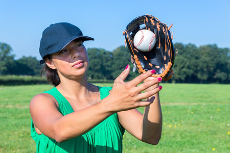 重新创建戴手套和帽子的女在户外打棒球活动荷兰语图片