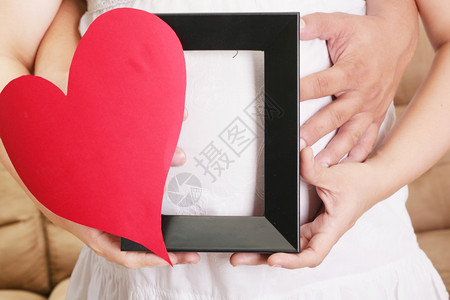 手握着木板和心脏手握着一个孕妇的肚子手握着她的妈多米尼奇生活图片