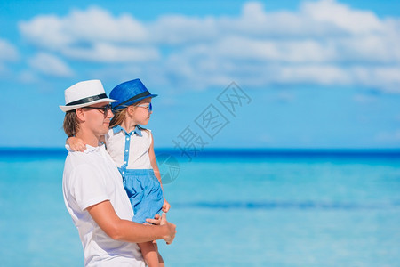 快乐的父亲和小女孩在海滩上小女孩和快乐的爸在海滩度假期间玩得开心育儿夏天门户14图片