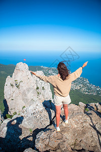 提高白种人在悬崖边缘的快乐女人享受在山顶岩的景色旅游女客在海边悬崖背景的缘探索图片