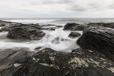 宁静冲浪岩海滨的景象石海岸田园诗般的图片