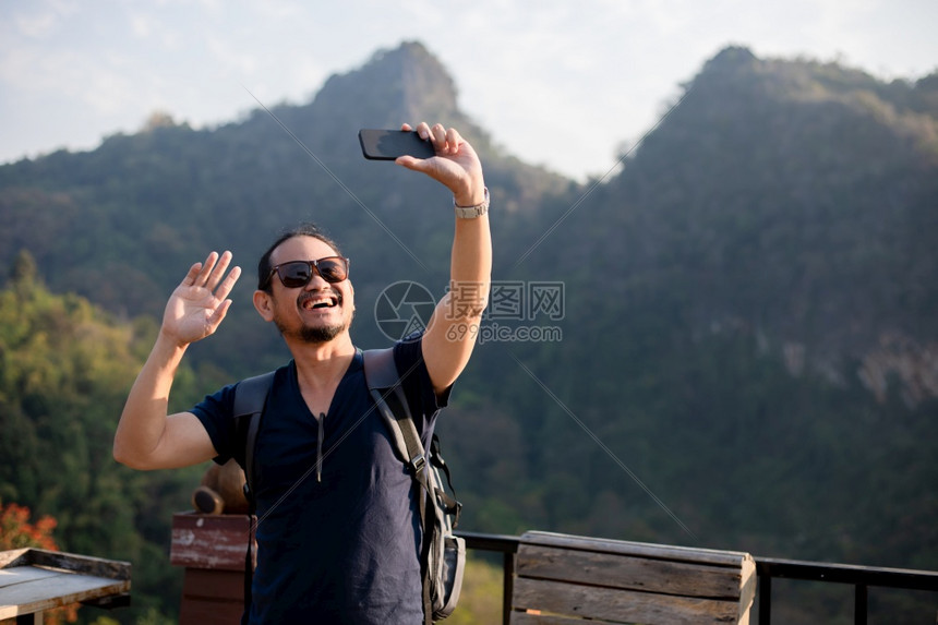 乐趣亚洲男旅游者正在使用手机自拍通过社交网络在媒体上分享校对Soup联网电话图片