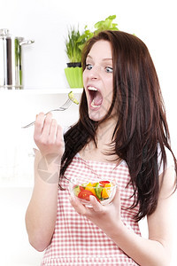 有趣的笑女人吃沙拉笑女人张开嘴眼睛吃沙拉饮食素主义者图片