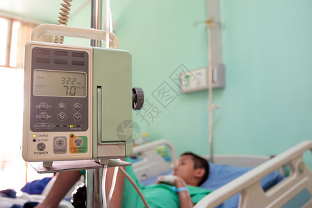 男审查一个亚洲男孩在医院的病床上治疗一个人保护图片