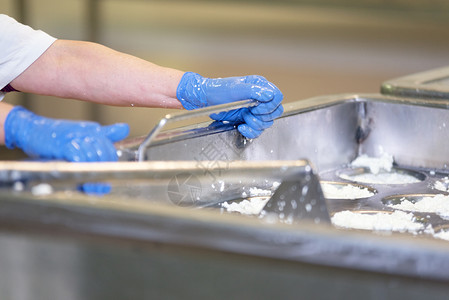 商业牛奶生的在酪制造厂发酵过程中在不锈钢罐混合生奶酪的人在制造厂的发酵过程中在不锈钢罐混合生奶酪的人图片