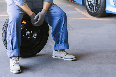 男人维护膨胀亚洲汽车检查测量数充气橡胶轮胎汽车特写手持轮胎和蓝色汽车用于的轮胎压力测量汽车行业形象图片