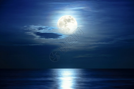 浪漫的午夜时分超满月和蓝天的色空中超级满月和云雾在海洋地平线上方月光反映水面和波浪夜晚海景中美丽的自然风景观作为背黑暗颜色图片