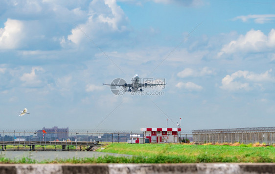 航程客机在场起飞空中有美丽的蓝天和白毛云飞行时过机场铁丝网围栏上空自由概念白鸟在机场的飞下翔旅行空气图片