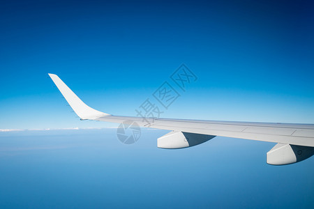 天线空气白云上的飞机翼在蓝天上行机窗外的风景商业航空公司飞行机翼在云层之上飞行力学概念国际航班图片