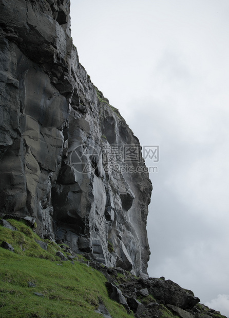 墙高的在法罗群岛瓦加尔的左侧用石头楼梯下雨后由火山起源的湿黑色岩壁垂直彩地形图像法罗群岛光荣景象法罗群岛的贺卡图案有质感的图片