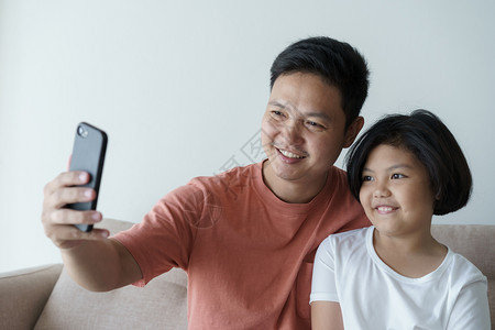 这个亚洲家庭有一父亲和女儿一个小孩和父亲的视频电话他们在家里很快乐她家技术照片成人图片