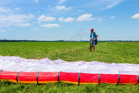 伞兵男人年轻的滑翔伞在草原等待降落伞床垫图片