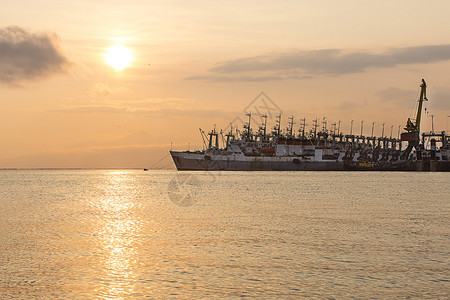 云俄罗斯码头上的渔船堪察加码头上正在下降的渔船队拖网图片