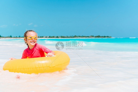 小女孩在沙滩上玩游泳圈图片