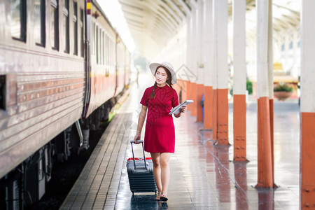 淑女幸福在火车站旅行中带红色手提箱的亚洲孕妇穿红衣旅行车站人类图片