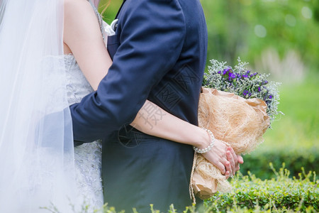 带着一束美丽花朵的新婚夫妇是爱与姻的象征手指快乐的女士图片