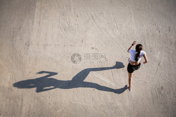 合身亚裔女在城市公路上跑步和的顶端景象健康最佳图片
