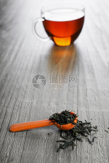 在旧木桌上用勺子泡绿叶茶和汤匙喝疏松品尝图片