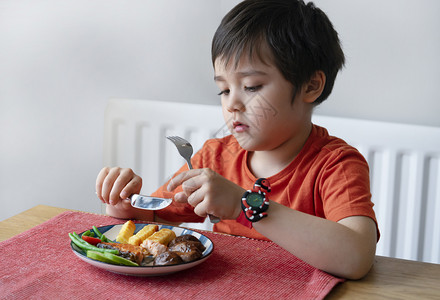 筹码幼儿园在家吃周日晚饭牛排鲑鱼和薯片吃午餐的不快乐儿童吃热菜和新鲜食物的儿童以及受污染儿童概念的无聊脸趣孩子的肖像新鲜图片