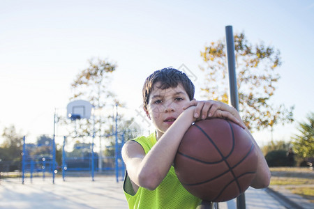 篮子一名无袖青年男子站在街头篮球场上对着镜头微笑一名无袖青年男子站在街头篮球场上对着镜头微笑街道游戏图片