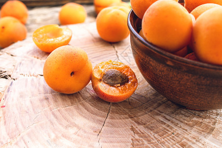 成熟的黄杏放在靠近子的木桌上碗里营养美味桌子背景图片