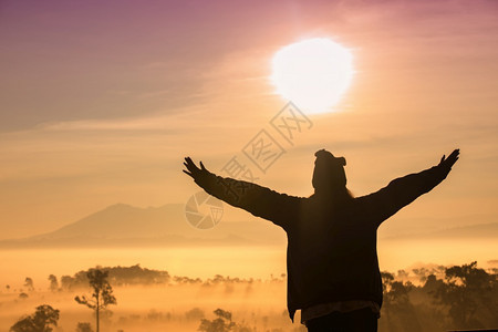 自由旅行者女神的休光月她们带着举起的手站享受美丽的大自然在日落和雾时欢呼青年游客多雾路段景观图片