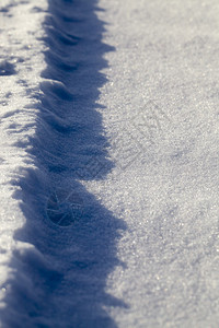 大雪纷飞颜色天气美丽的车轨迹被阳光照亮雪从粗糙中获得了一个有趣的外观从车轨迹上设计图片