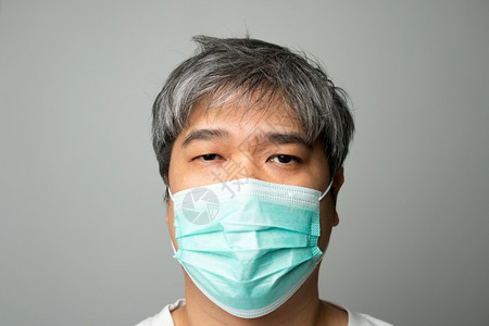 戴医疗面罩肩部疼痛和压力的亚洲病男子身穿医疗面罩和肩部疼痛压力保护大流行冠状和呼吸道疾概念精神的咳嗽健康图片