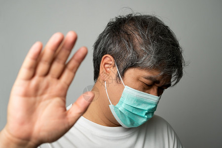 男面具戴医疗罩肩部疼痛和压力的亚洲病男子身穿医疗面罩和肩部疼痛压力保护大流行冠状和呼吸道疾概念男人图片