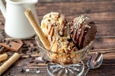 盘子巧克力奶油和焦糖罗马人冰淇淋在玻璃碗里加了栗子和巧克力酱球各种样的图片