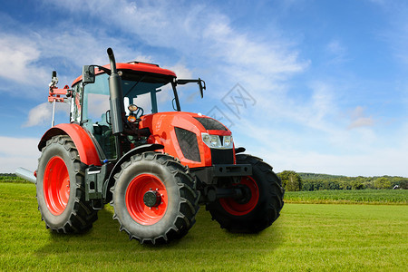 晴天现代的红色农业通用拖拉机在阳光明日绿色田地上的复合图象农场图片