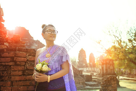 泰国女人露齿笑脸站着手里拿粉红色的莲花束亚洲快乐的人图片