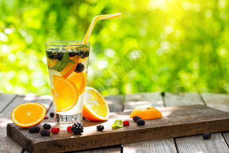 果汁新鲜的在阳光明媚夏日在表桌上的柑橘柠檬水太阳晴朗的夏日在桌子上浆果图片
