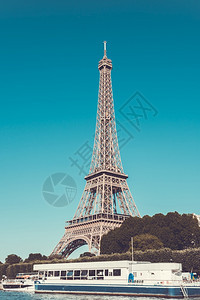 旅游船欧洲的埃菲尔塔和塞纳河在法国巴黎背景的蓝清天空下图片