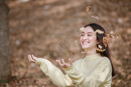 美丽的亚洲女在公园户外露天微笑快乐的女孩穿着温暖衣服冬天和秋肖像时尚天假期图片