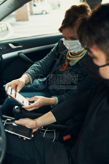 爆发关心坐在车里的男女用智能手机戴面罩避免感染防止疾在出现冠状腺毒时蔓延b使用智能手机戴上面罩以防止感染疾传播保护的图片