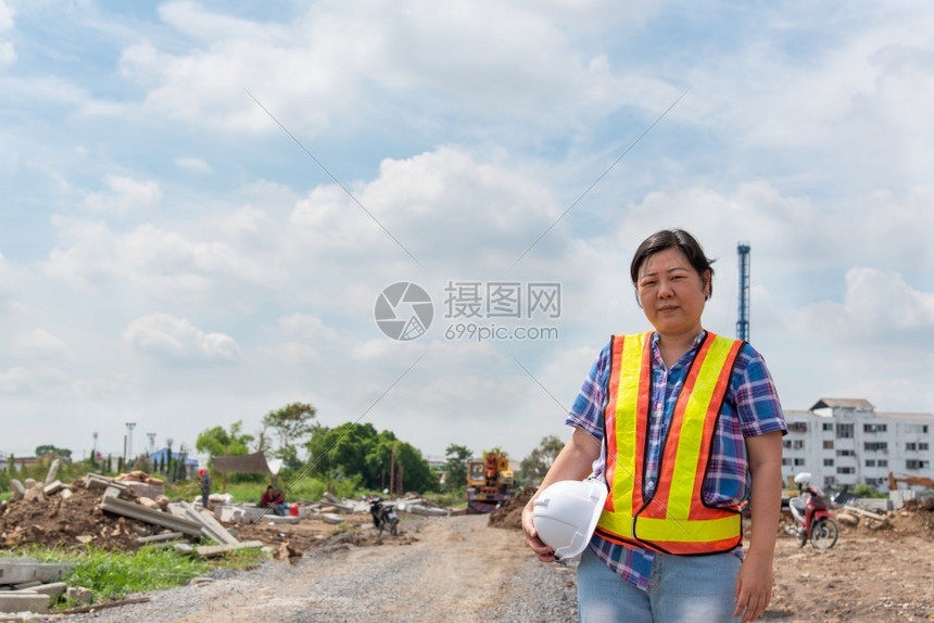 戴着头盔和安全背心的亚洲女土木建筑工程师或在工地作很开心建筑工地的女程师难的穿电脑图片