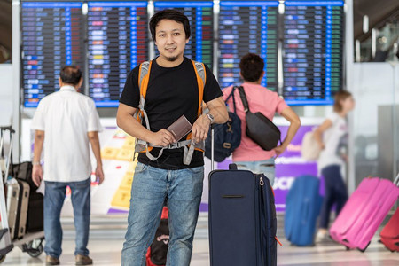 到达休息室人们在现代机场飞行信息屏幕上登机旅行和具有技术概念的运输等现代机场旅行和运输时有护照的亚洲旅行者在飞板上站立着检查行李图片