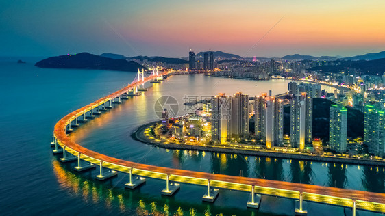 位于韩国釜山的光建大中桥或万安天线和摩大楼建筑在南韩釜山夜照亮著名的镇景观图片