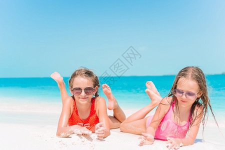 夏日度假时海滩上可爱的小女孩与绿海和白沙一起在滩上玩得开心美丽的小女孩在海滩上很快乐自然加勒比海洋图片
