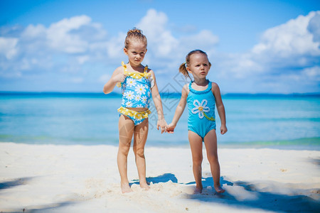 多于童年夏天日度假时海滩上可爱的小女孩与绿海和白沙一起在滩上玩得开心美丽的小女孩在海滩上很快乐图片