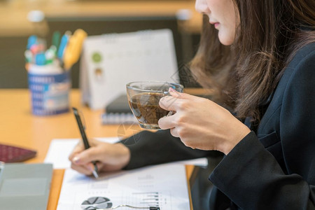 在现代办公室或会议商业和工人概念中处理电脑笔记本和办公用品时手喝咖啡的封闭式商业女人手头饮咖啡现代的男人茶图片