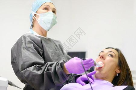 医生用口内相机检查病人牙齿高质量照片医生用口内相机检查病人牙齿在职的制服水平图片