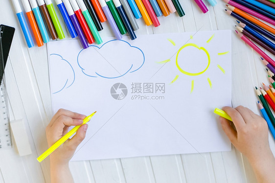 童子手用彩色铅笔涂在木制桌上一张白纸童子手用彩色铅笔画在纸上颜色婴儿白的图片