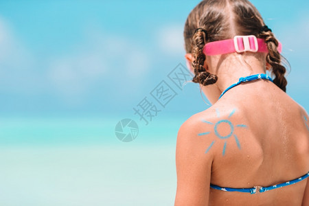 用防晒霜涂在孩子肩上的太阳特写图片