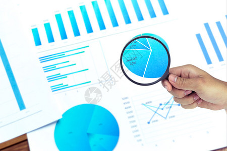 经济的商业人使用放大镜分析公司报价数据和图表中的统计数字并用放大镜来分析数据资金图片